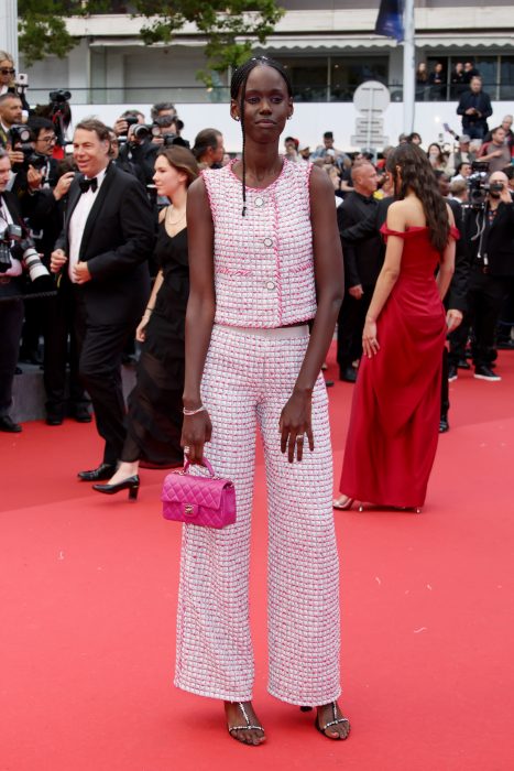 Ramata-Toulaye Sy porte un gilet en tweed rose fuchsia et blanc et un pantalon droit orné d’une tresse, look 7, de la collection Haute Couture printemps-été 2021 CHANEL